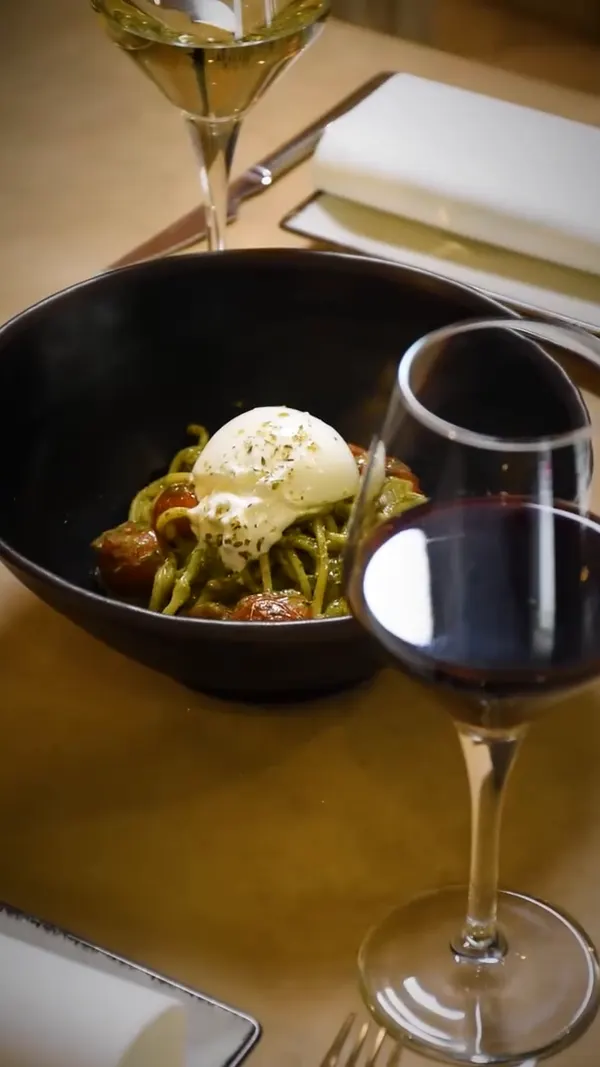 El plato en la mesa, junto a una copa de vino tinto.